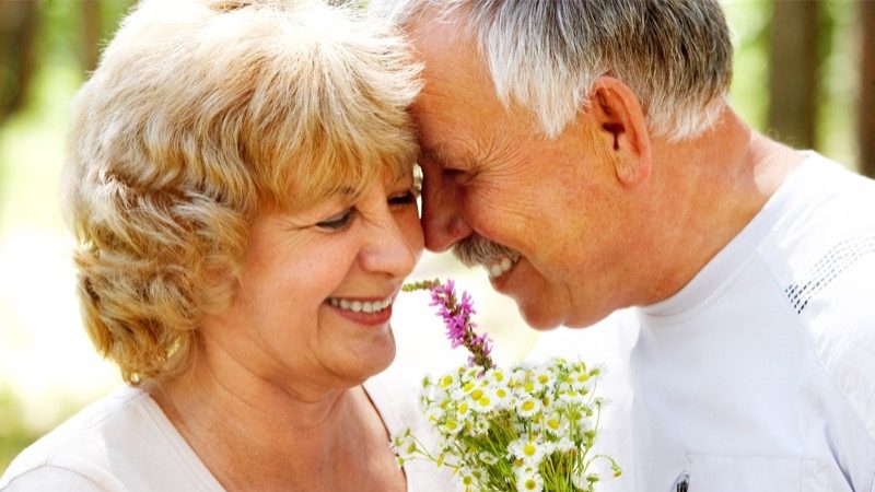 Motiv: Ældre ægtepar tæt sammen. De ler fortroligt.