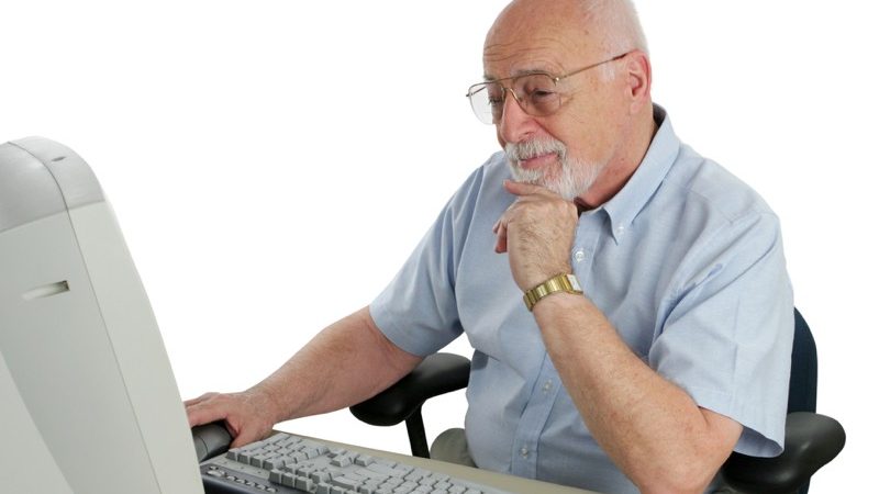 Motiv: Ældre mand sidder ved en gammel computer