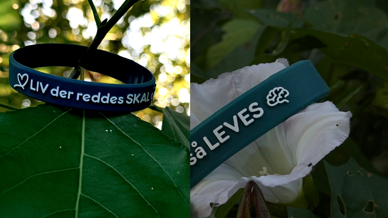 Silikonearmbånd – viser de to symboler ved siden af teksten Liv der reddes skal også leves: et hjerte og en hjerne